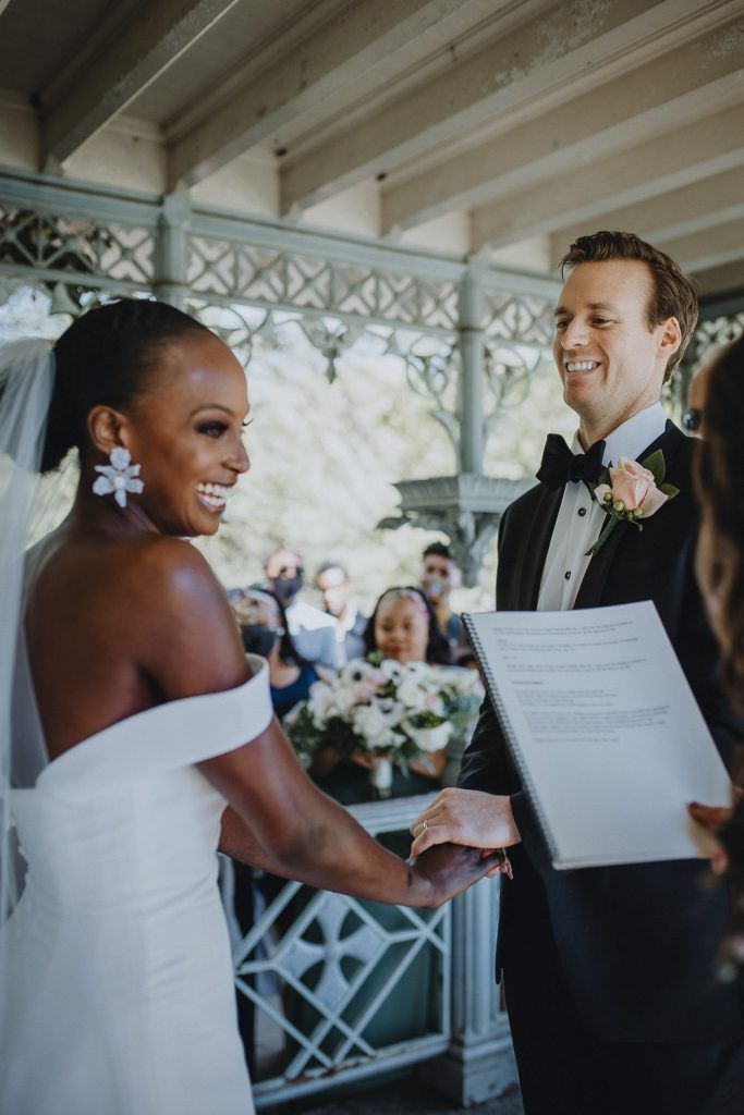Wedding ceremony of biracial bride and groom in central park