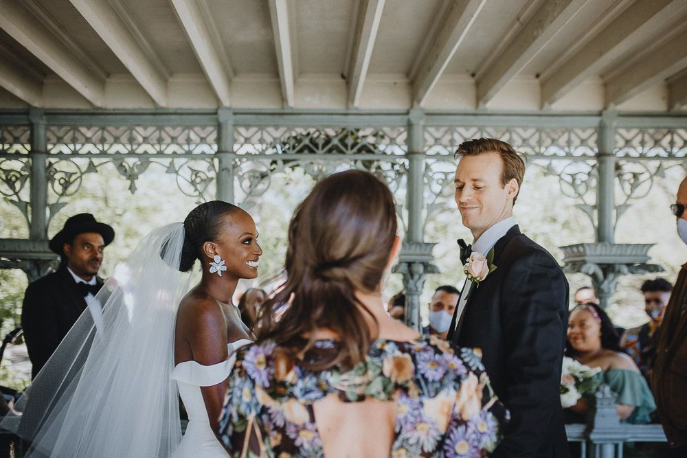 Wedding ceremony of biracial bride and groom in central park