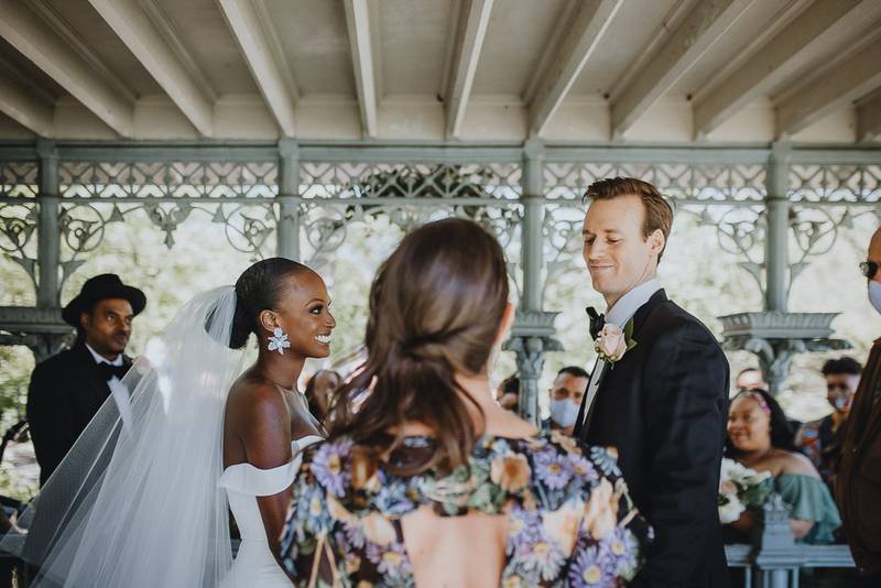 Wedding ceremony of biracial bride and groom in central park