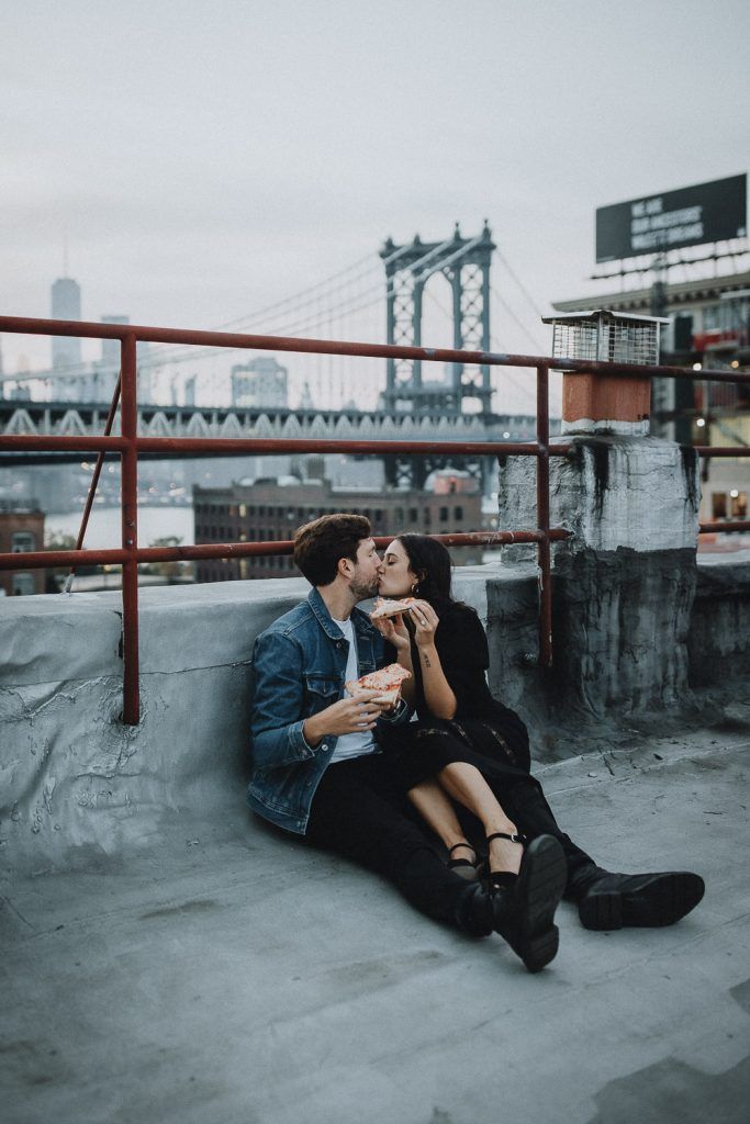 Couple eating pizza during brooklyn rooftop engagement session