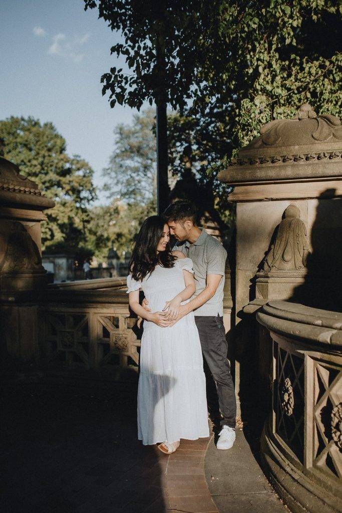 Expecting couple in central park at bethesda terrace during maternity photoshoot