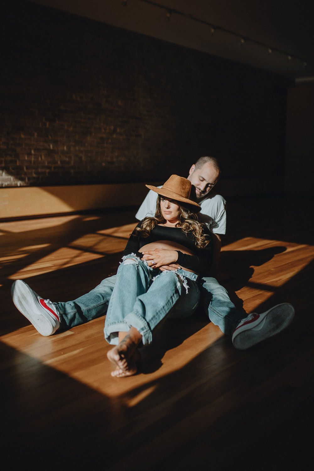 Expecting couple during intimate maternity session in nyc home