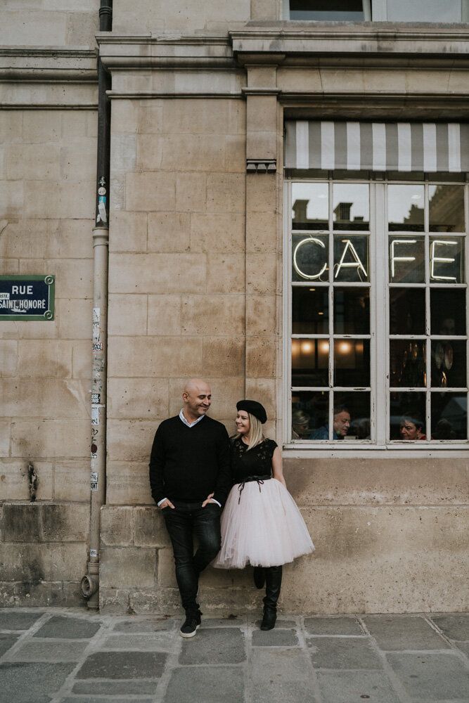 Couple standing by cute cafe during paris engagement session