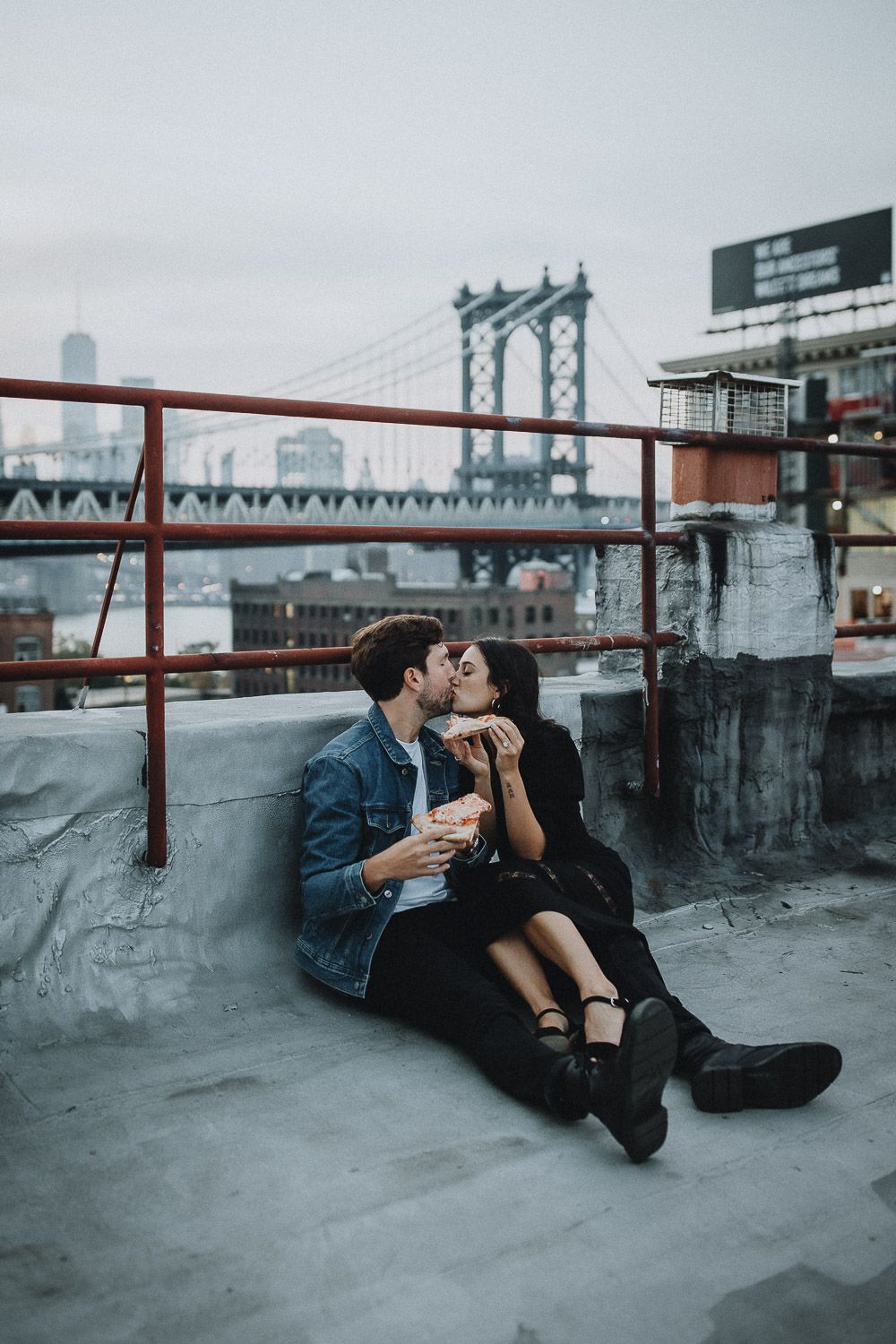 Couple eating pizza during brooklyn rooftop engagement session