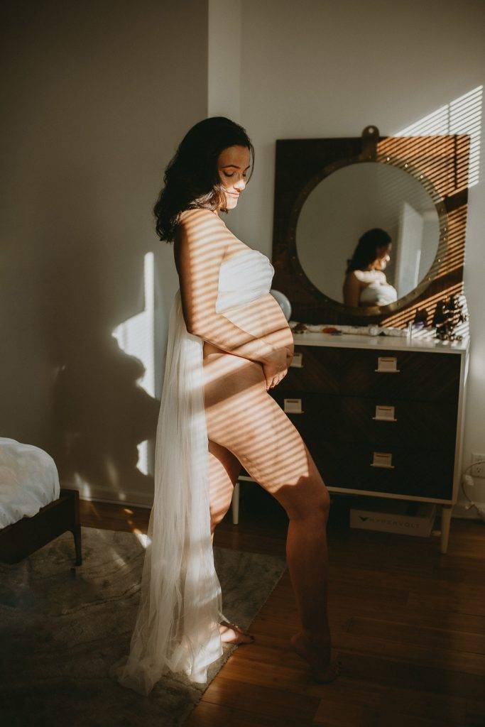 Naked pregnant woman during maternity photoshoot at home in brooklyn