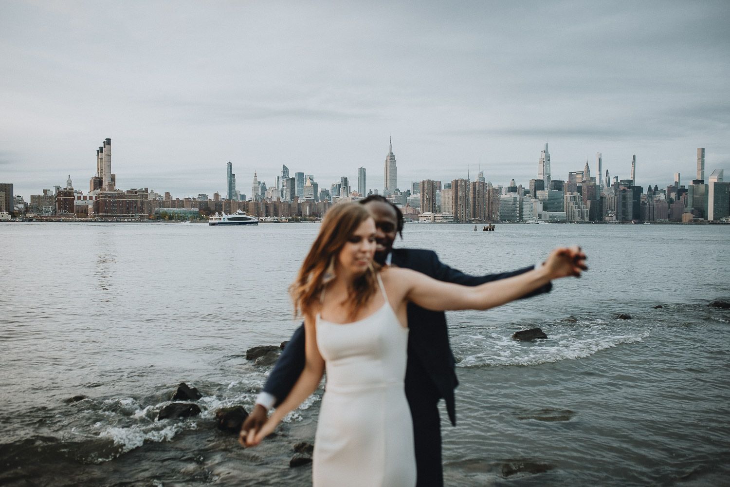 Interracial bride and groom with nyc skyline during brooklyn elopement