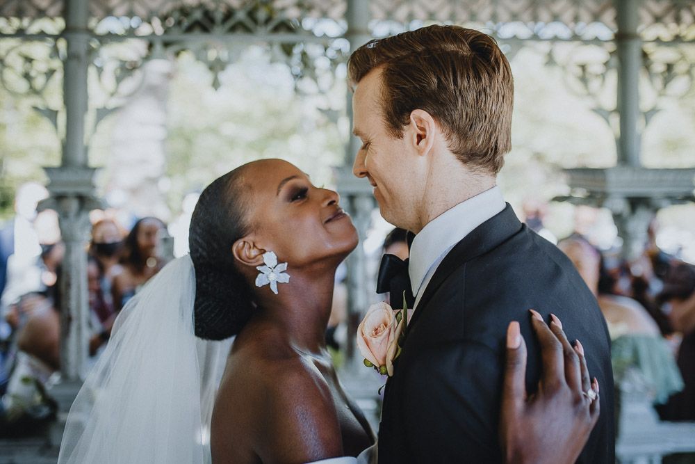Wedding ceremony of biracial bride and groom in central park