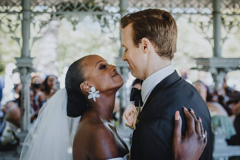Wedding ceremony of biracial bride and groom in central park