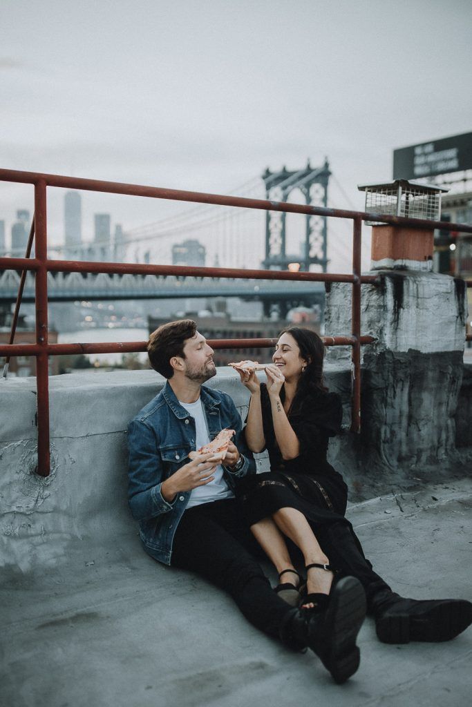 Couple eating pizza during brooklyn rooftop engagement session