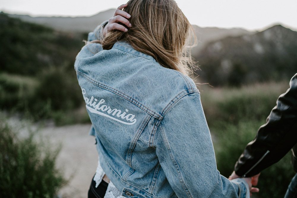Woman holds boyfriend's hand during engagement session in los angeles canyon