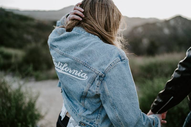 Woman holds boyfriend's hand during engagement session in los angeles canyon