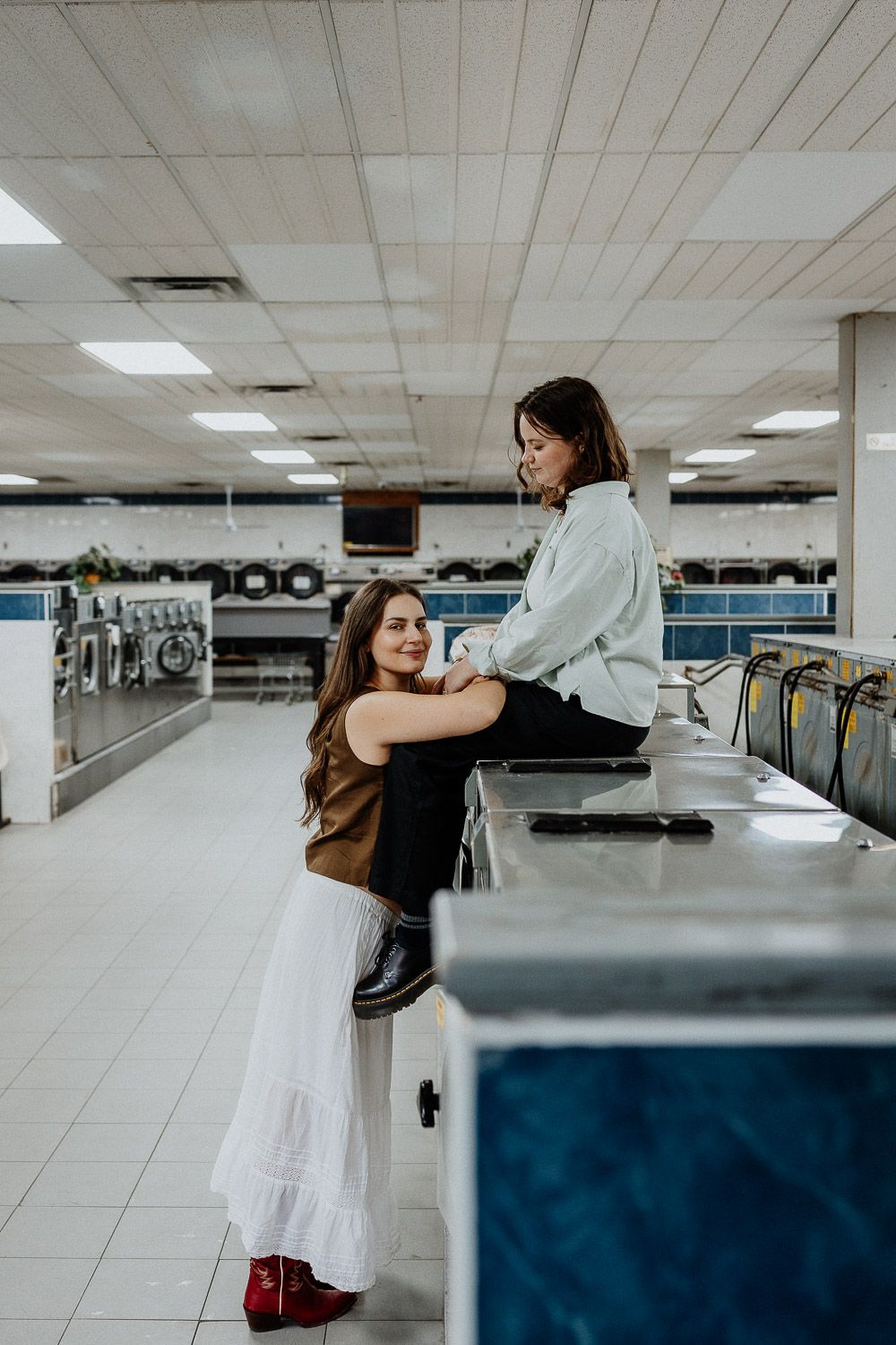 Lesbian couple during engagement photoshoot in brooklyn laundromat