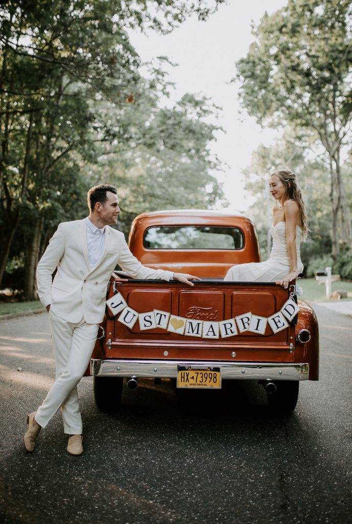 Bride and groom in vintage Ford truck at hamptons wedding