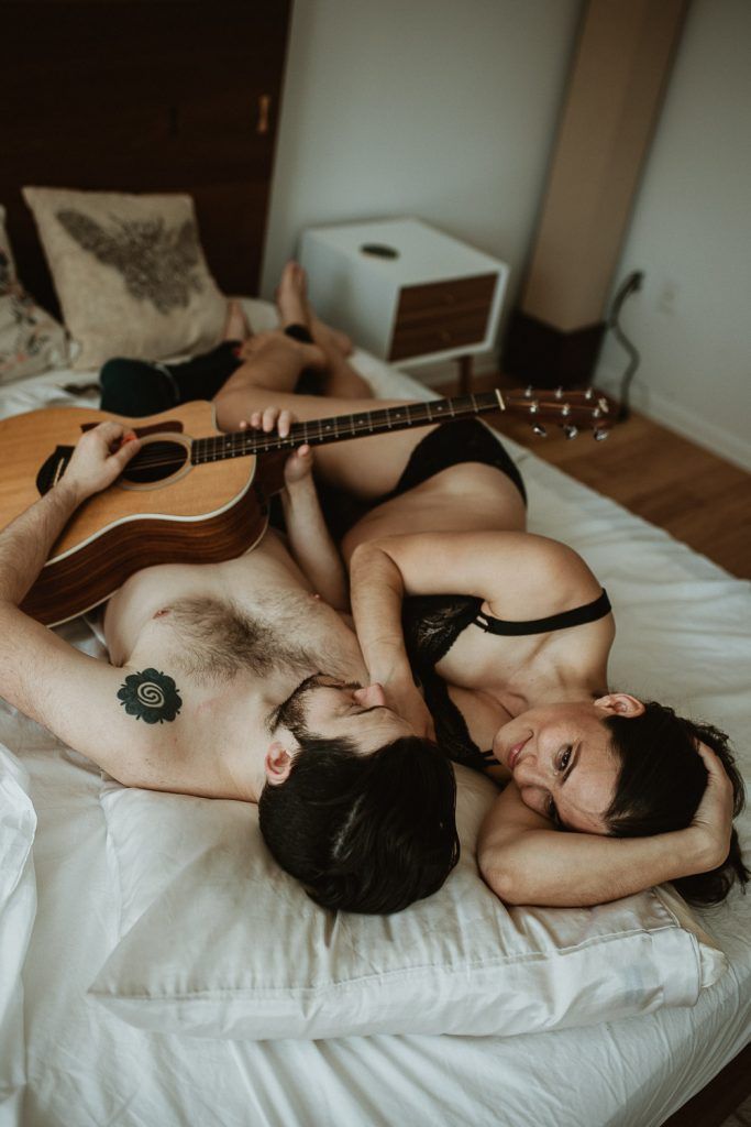 Expecting couple plays guitar in bed during maternity shoot in brooklyn home