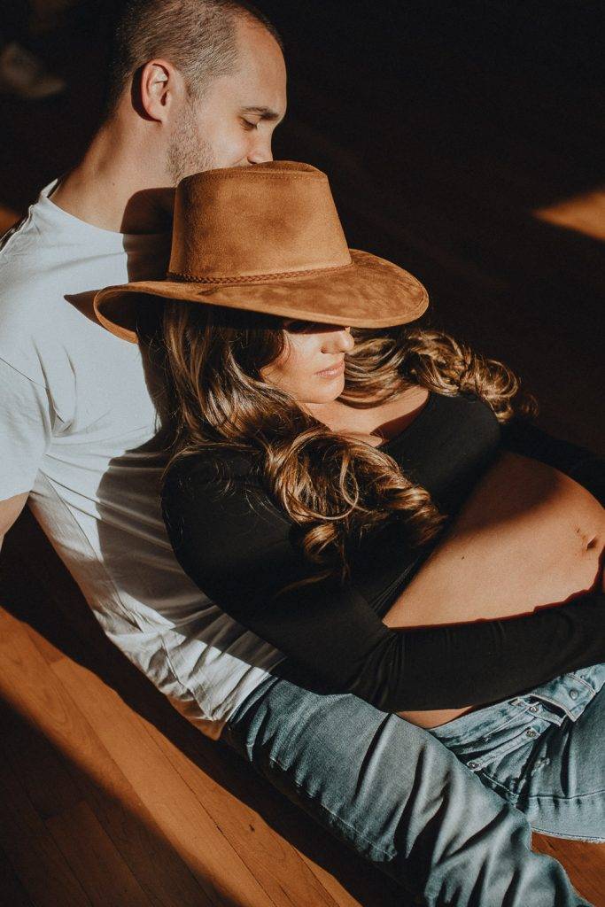 Expecting couple during intimate maternity session in nyc home