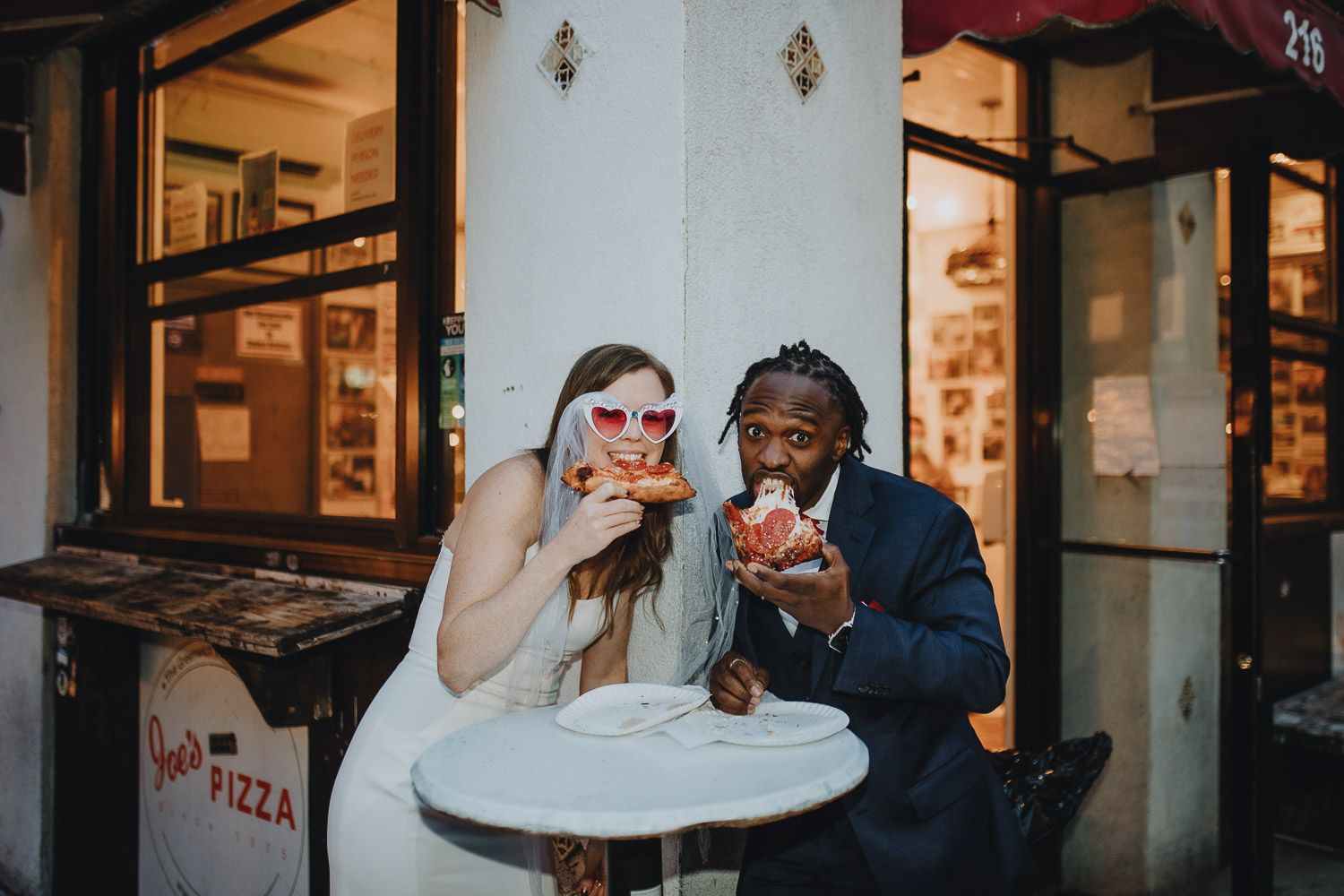 Interracial bride and groom eating pizza during brooklyn elopement