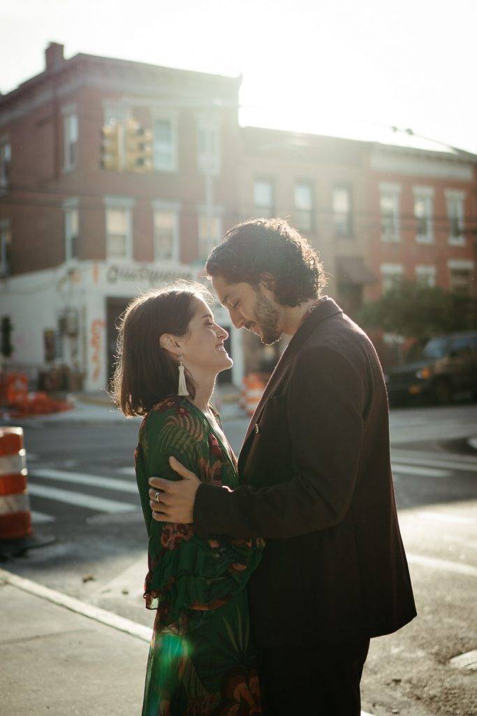 Couple snuggling in brooklyn at sunrise during elopement
