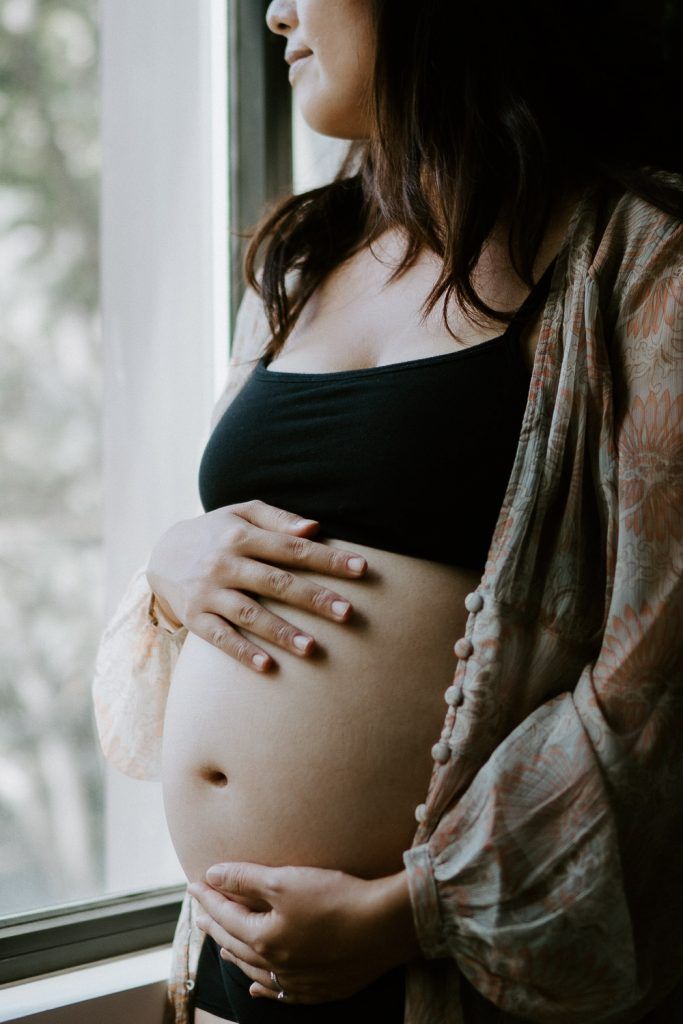 Pregnant woman showing baby bump during maternity session in brooklyn