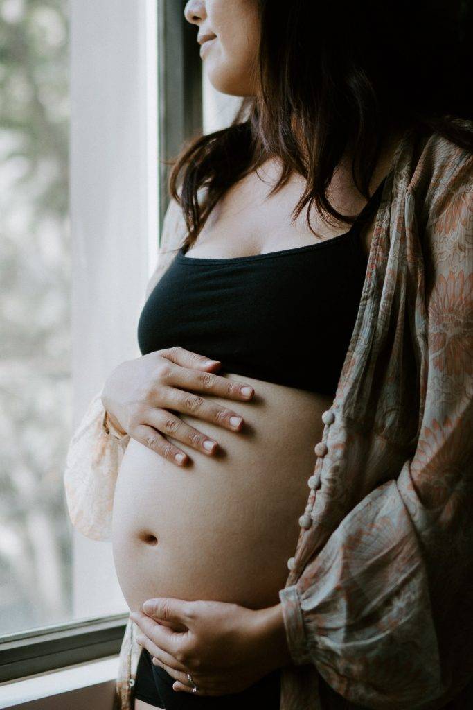 Pregnant woman showing baby bump during maternity session in brooklyn
