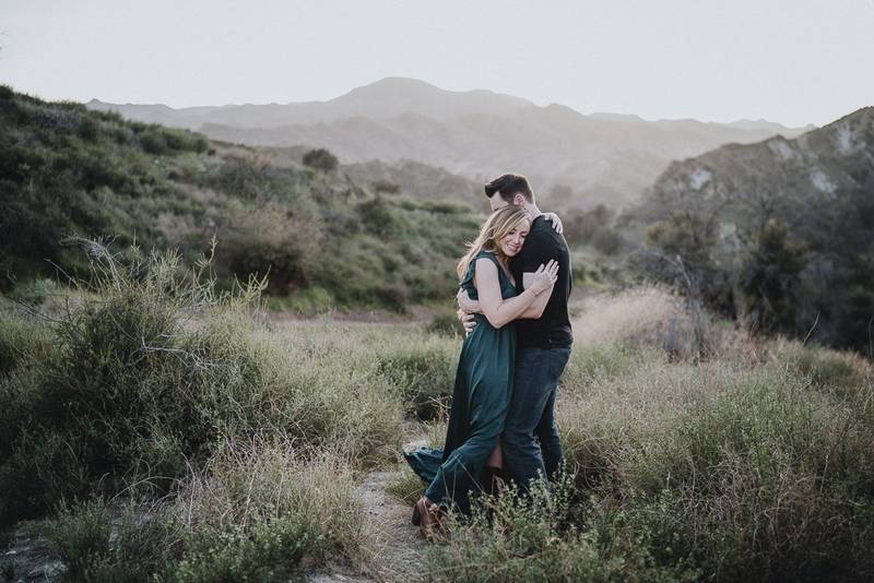 Couple cuddles during engagement session in los angeles canyon