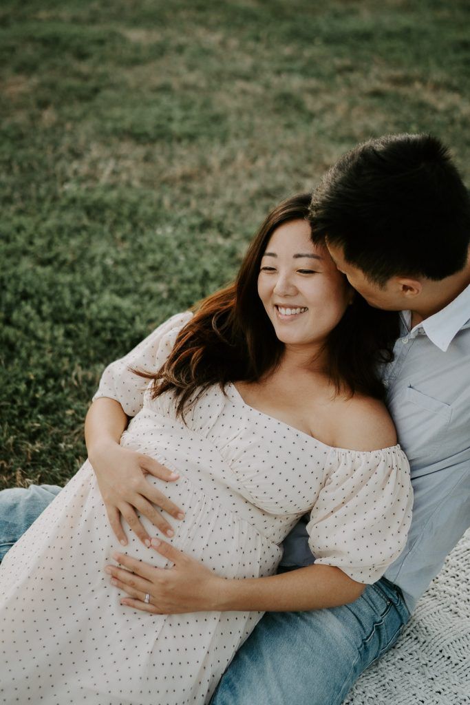 Expecting couple snuggles in prospect park during maternity session