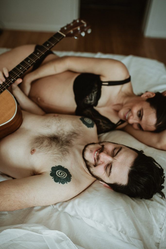 Expecting couple plays guitar in bed during maternity shoot in brooklyn home