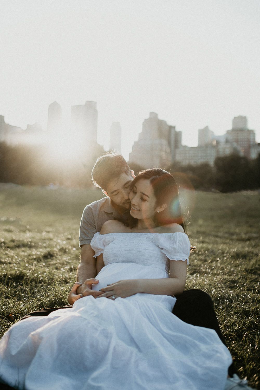 Expecting couple in central park at golden hour during maternity photoshoot