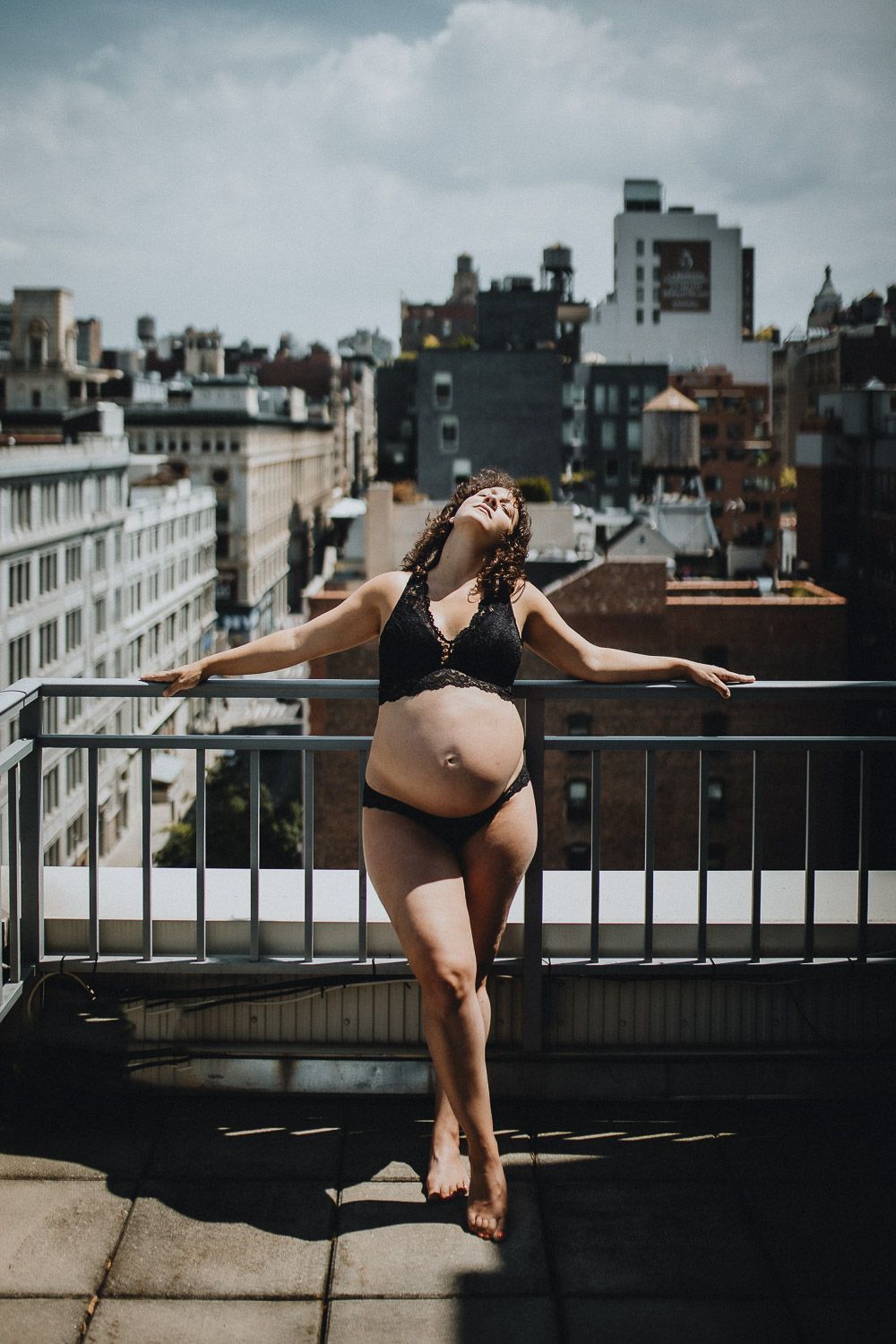 Pregnant woman on nyc rooftop during intimate maternity session at home