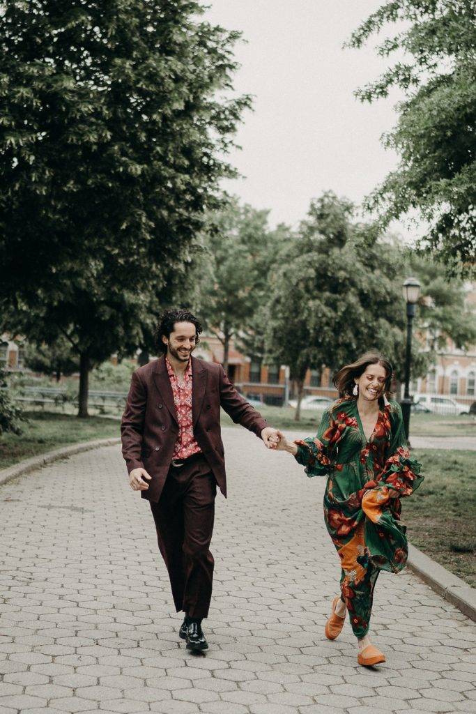 Couple holds hands and runs in brooklyn park during elopement