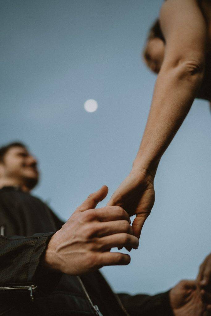 Couple holding hands under the moon at blue hour
