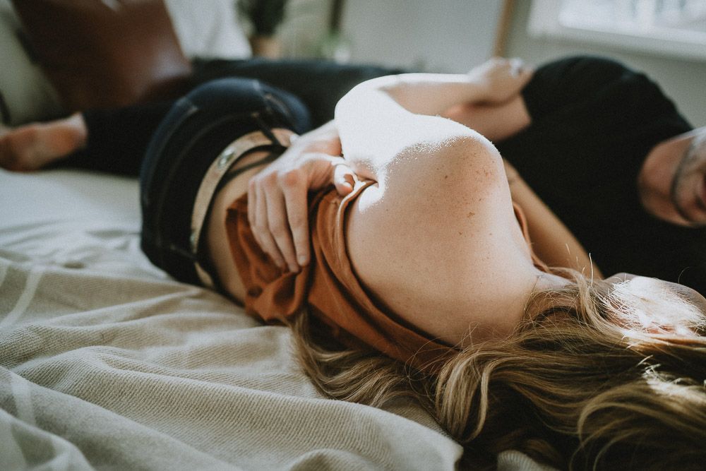 Couple cuddles in bed during in home session in brooklyn