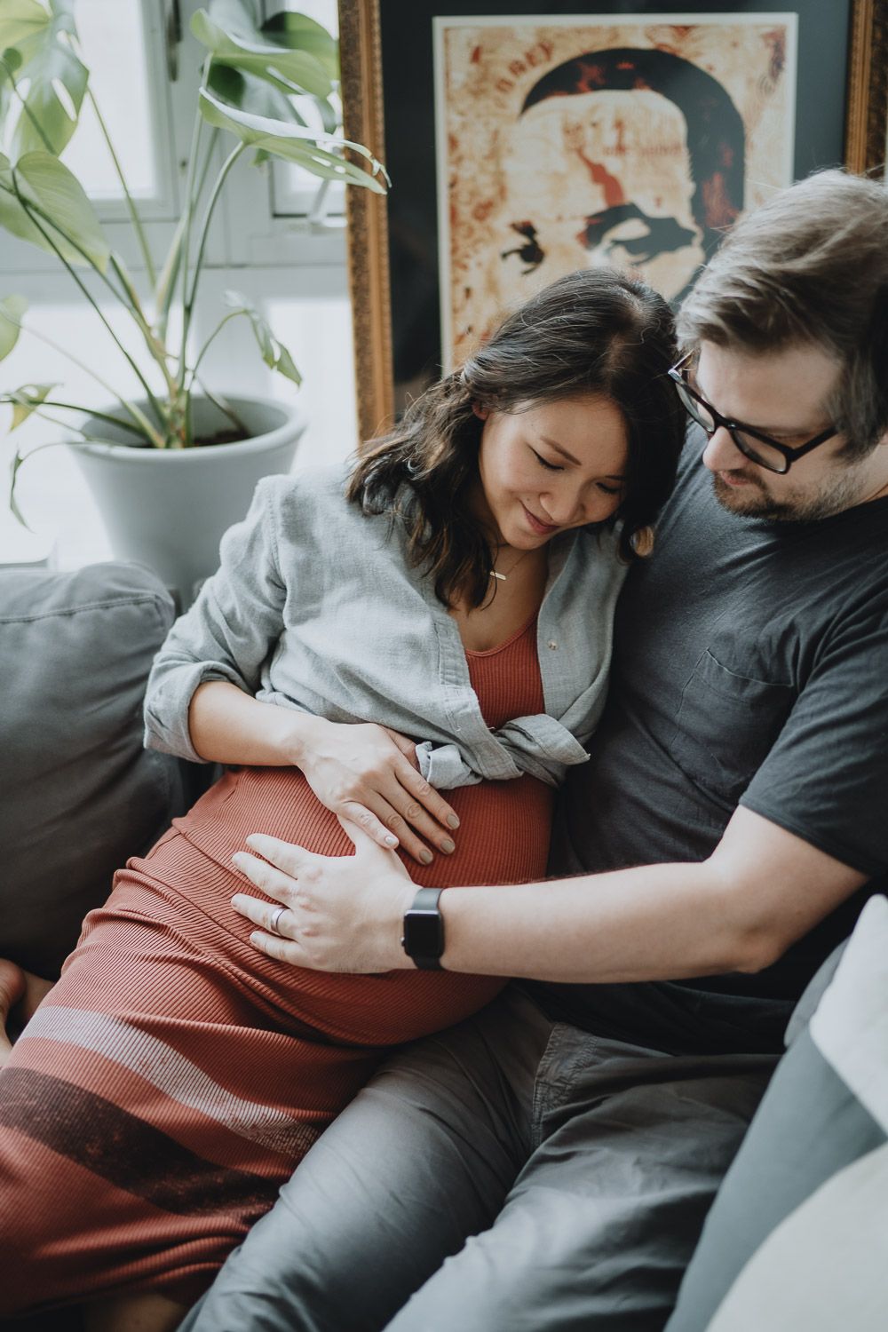 Expecting couple touches baby bump during in home maternity session in brooklyn