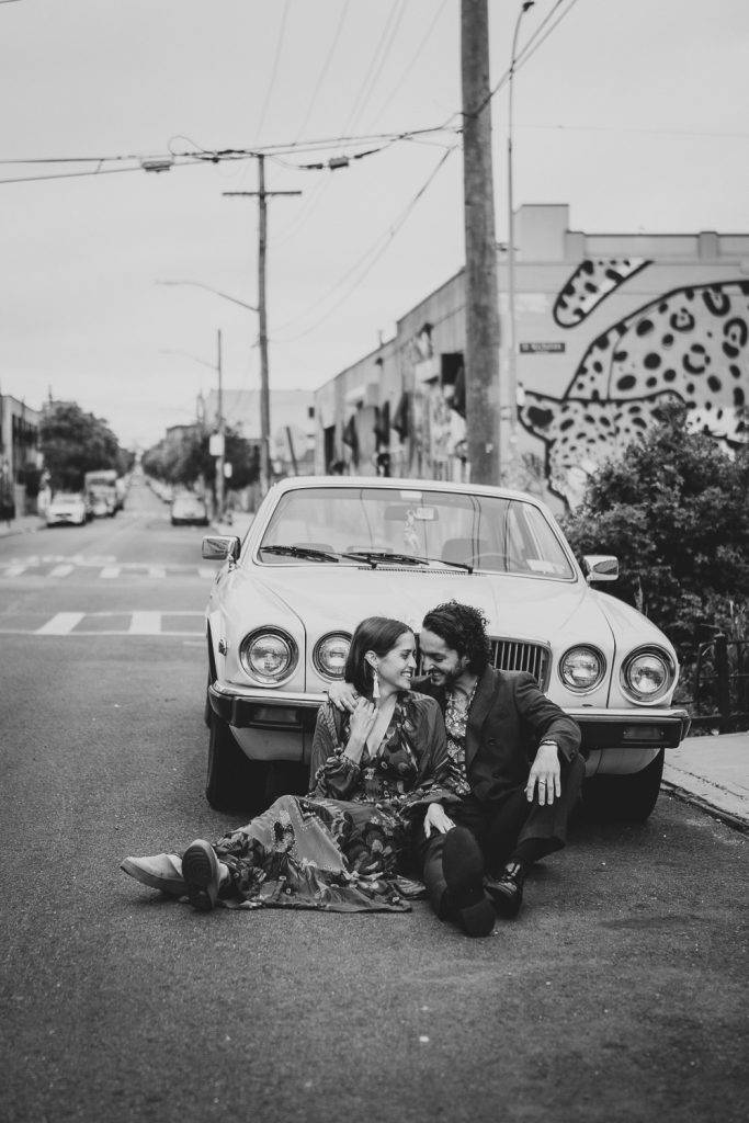 Couple sitting against old vintage car during brooklyn elopement