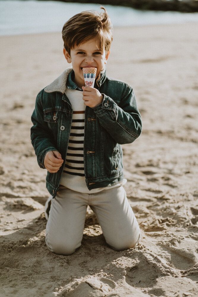 Young boy eats ice cream during family session at coney island beach