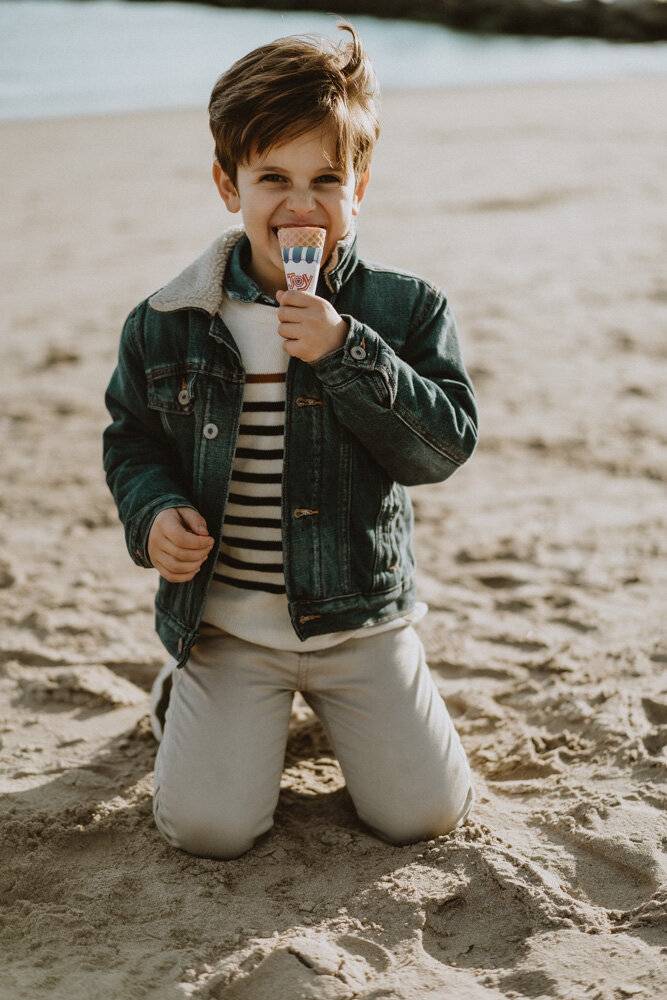 Young boy eats ice cream during family session at coney island beach