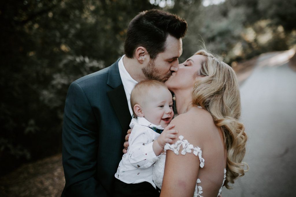 Bride and groom with their baby in hills of los angeles