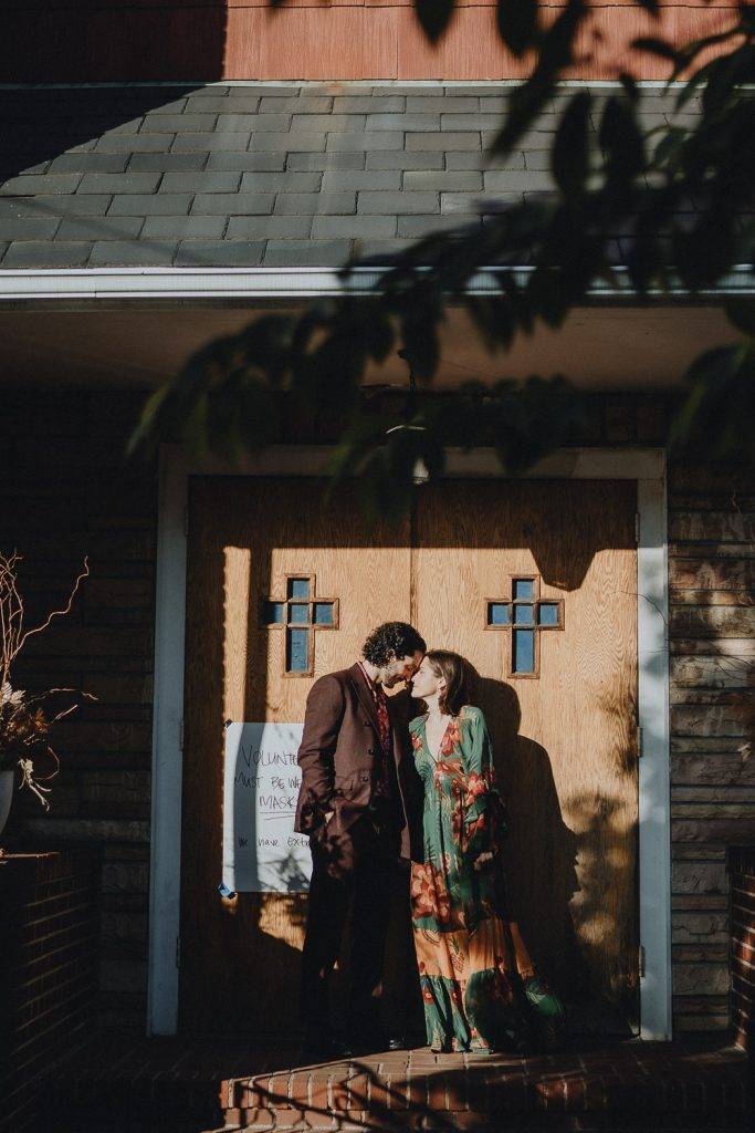 Couple snuggling in front of church during brooklyn elopement