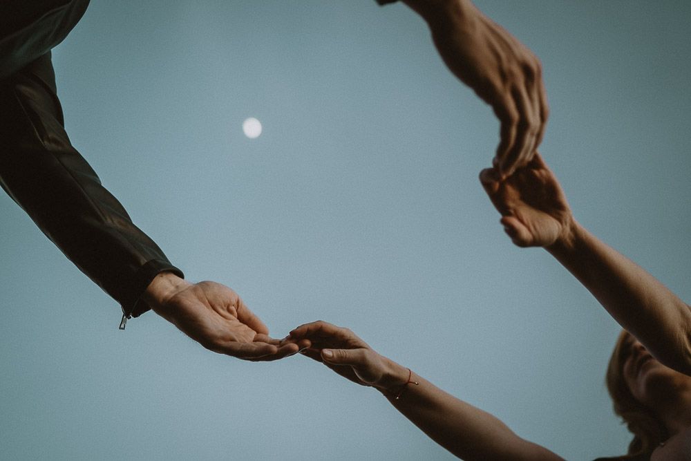 Couple holding hands under the moon at blue hour