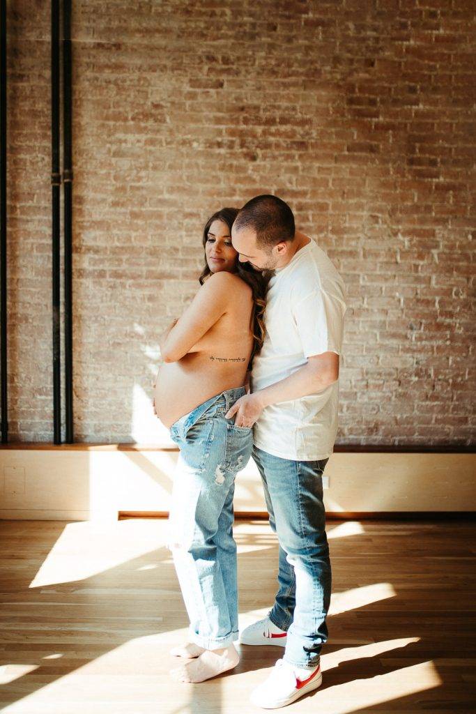 Expecting couple during intimate maternity session in nyc home