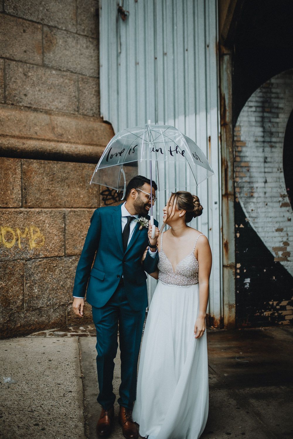 Bride and groom under clear umbrella during dumbo brooklyn elopement