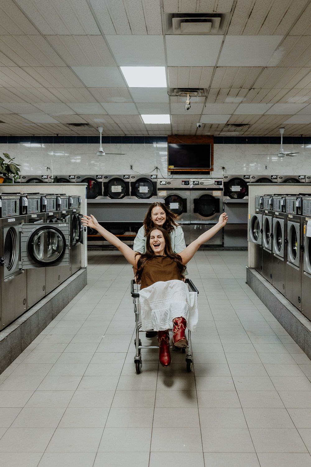 Lesbian couple during engagement photoshoot in brooklyn laundromat