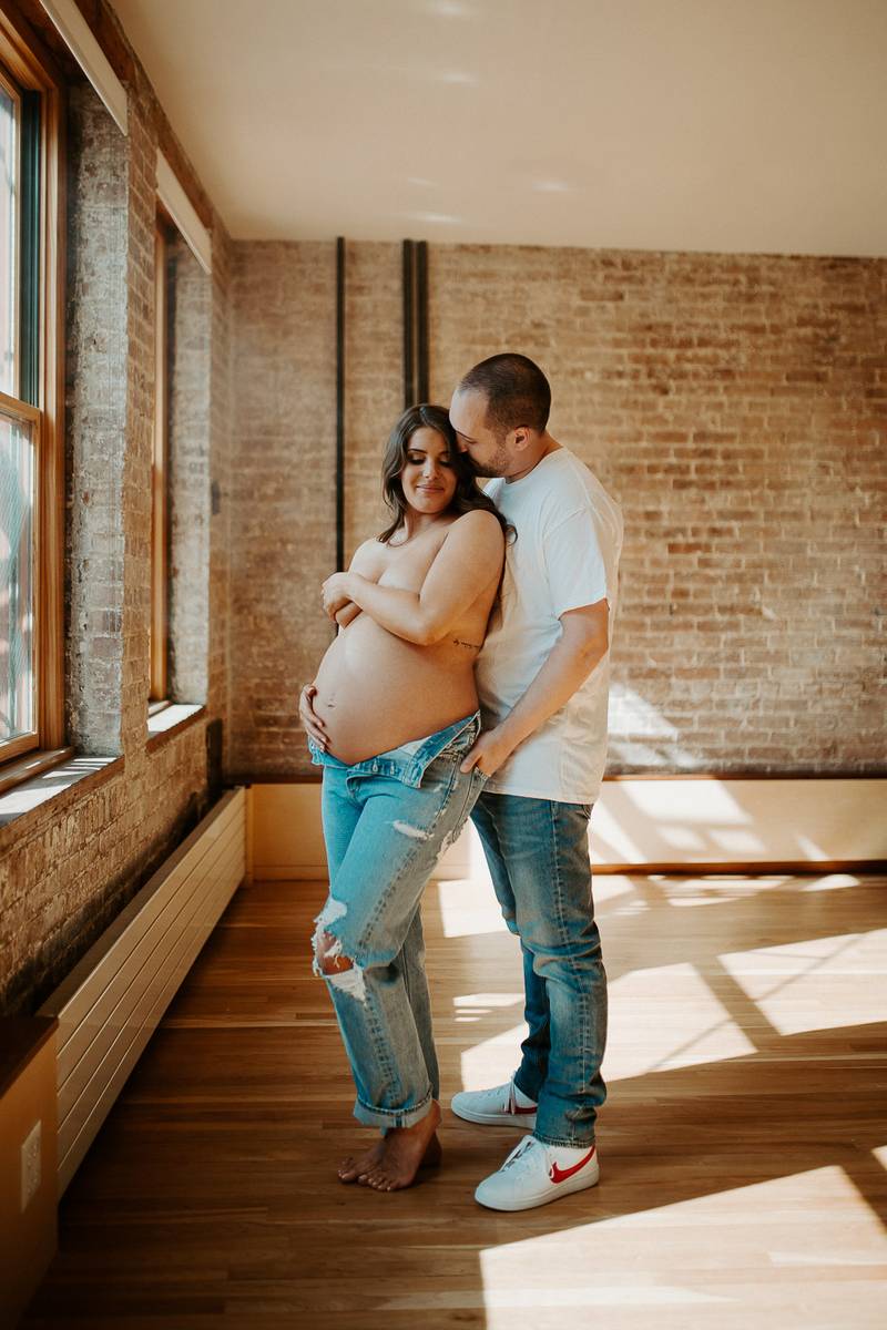 Expecting couple during intimate maternity session in nyc home