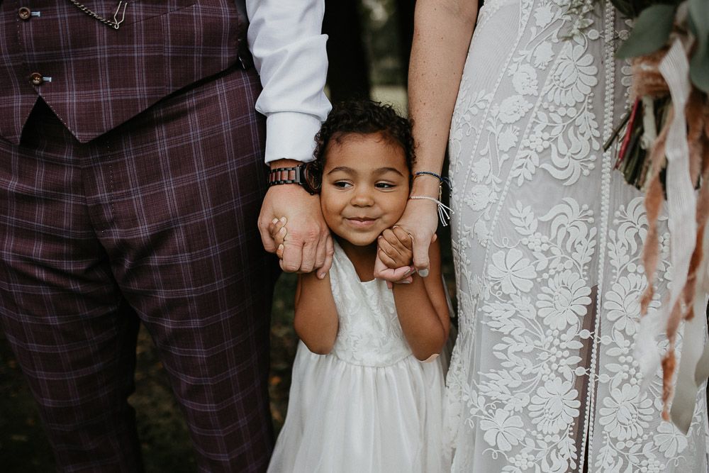 Flower girl with bride and groom at fall backyard wedding in new jersey