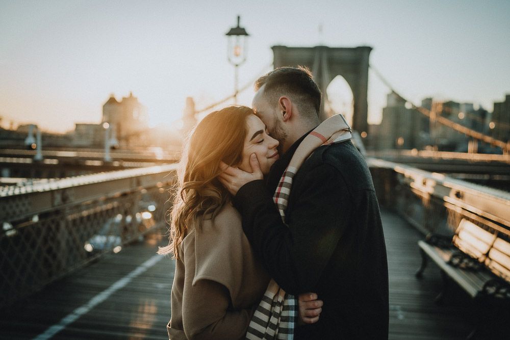 Couple on brooklyn bridge at sunrise during engagement session