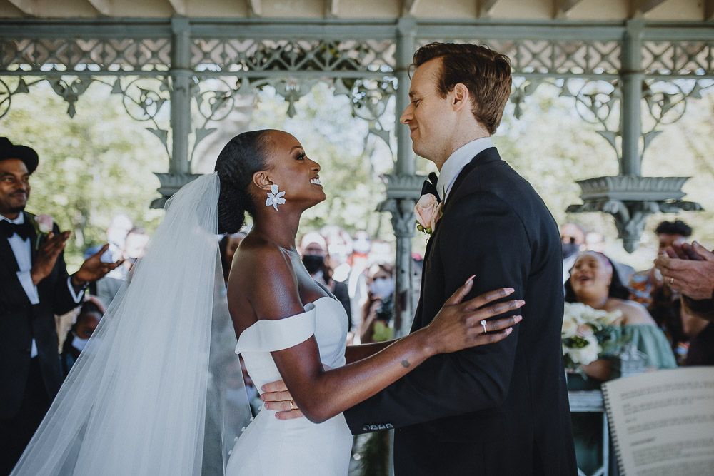 Wedding ceremony of biracial bride and groom in central park