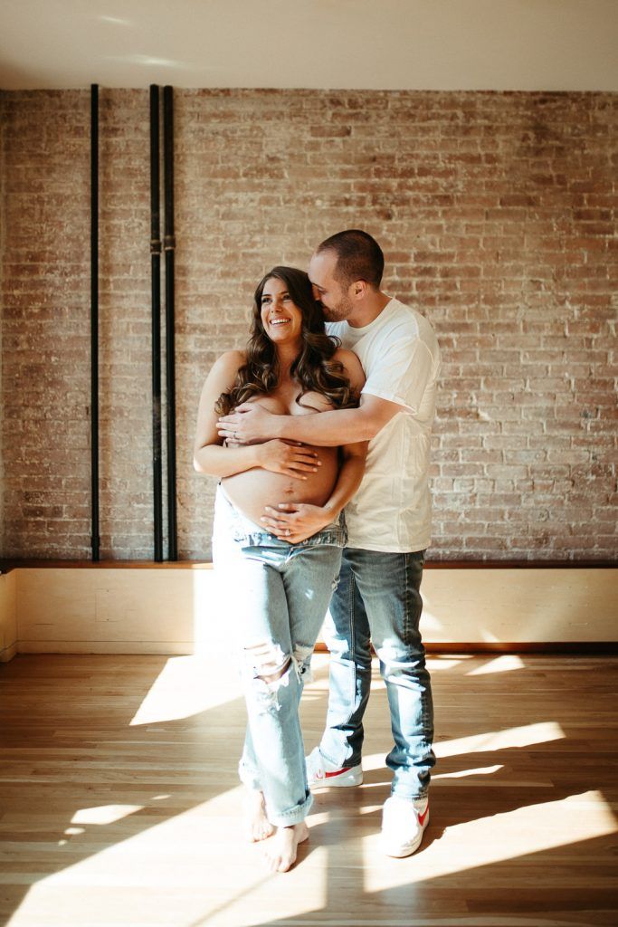 Expecting couple during intimate maternity session in nyc home