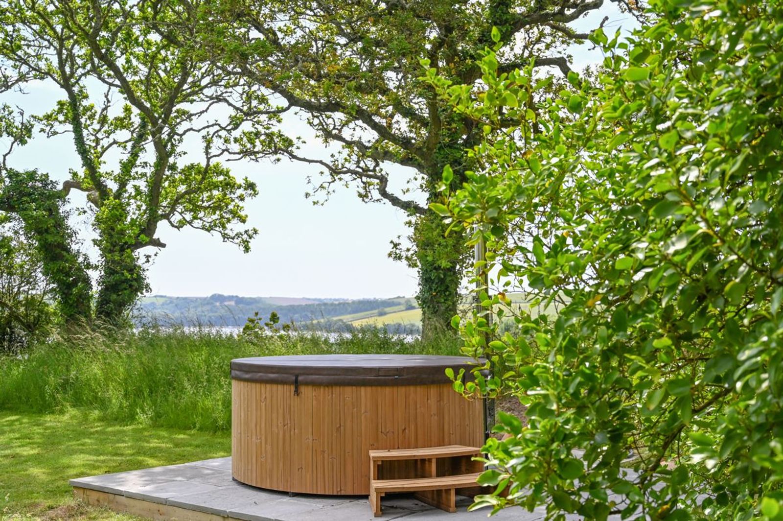 A wood-fired hot tub in a hidden corner of the garden, looking towards the river