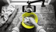 How to make faceless videos: an overhead phone mount films only a pair of hands kneading dough in a yellow bowl on a wooden table