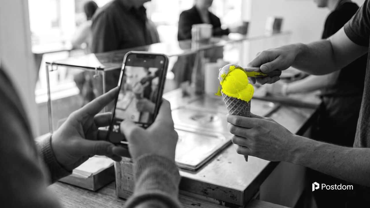 How to go viral on Instagram: a phone films a scoop of yellow lemon sorbet being placed on a cone at an ice cream shop counter