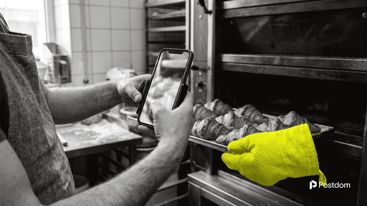 How to make YouTube Shorts: a baker films a tray of fresh croissants coming out of the oven with a phone held upright, a yellow oven mitt on the tray